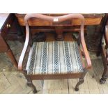 A mahogany piano stool with a back and carver arms