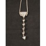 A white metal necklace set with triangular shaped drop,