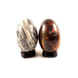 Two oriental natural stone eggs on stand,