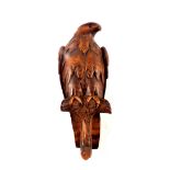 A Black Forest carved wood eagle with rear lidded compartment and glass eyes,