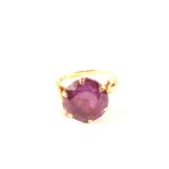 A continental gold ring set with a large purple stone,