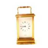 A brass carriage clock with white enamel dial, 11 jewel key wind movement,