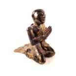 An Asian gilt decorated wooden praying figure with applied glass decoration,