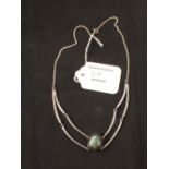 A white metal necklace set with single stone to centre (possibly labradorite),