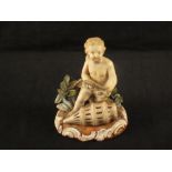 A 19th Century continental porcelain figure of a seated boy with fish and net (some chips and