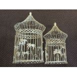 Two circular metal bird cages with palm leaf decoration