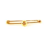 A yellow metal bar brooch set with single diamond