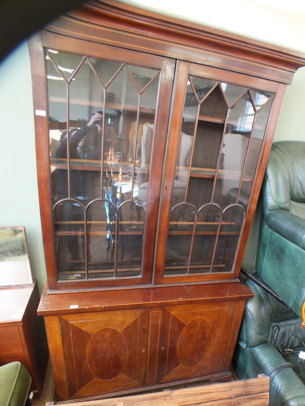 A large mahogany inlaid and glazed bookcase with two cupboards base (glazed door as found)