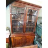 A large mahogany inlaid and glazed bookcase with two cupboards base (glazed door as found)