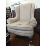 A Georgian style armchair in beige upholstery with carved front pad feet and matching foot stool