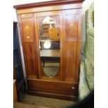 An Edwardian mahogany single mirrored door wardrobe flanked by urn inlaid panels