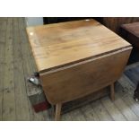 A light Ercol flap leaf kitchen table
