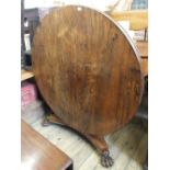 An early Victorian circular rosewood tilt top table on tripod base with ball and claw feet,