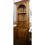 A pine single door corner cupboard with three shelves