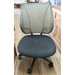 A modern Human Scale black office chair with adjustable green back