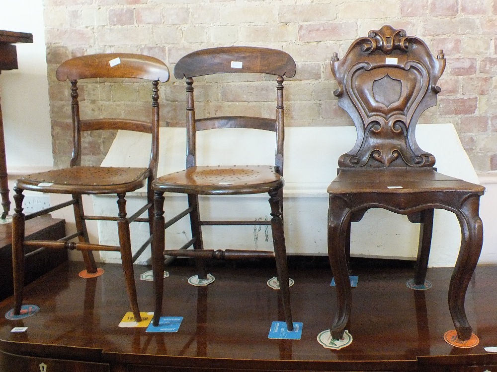 A carved hard seat hall chair on cabriole legs and two bedroom chairs