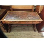 An oak and walnut veneer writing table with two drawers and tooled leather inset top on stretcher