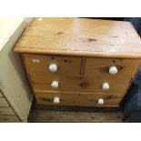 A Victorian stripped chest of two short and two long drawers with ceramic handles and turned feet