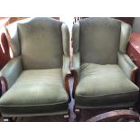 A pair of vintage wingback armchairs with pale green velour upholstery