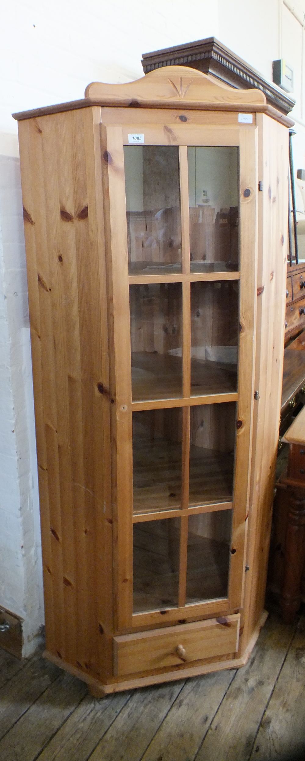 A glazed single door pine corner cupboard with single drawer