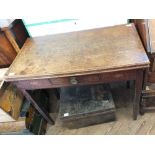 An oak tea table with central drawer on tapered legs