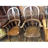 Two Windsor style spindle back elbow chairs with decorated central splat on turned legs (one as