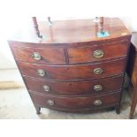 A flame mahogany bow fronted chest of short and three long drawers with metal handles on carved