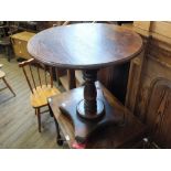 A circular stained pine pub table on pedestal base