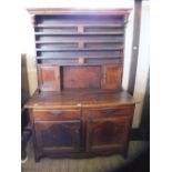 A large shelf back dresser with two small cupboard on a two drawer and two door cupboard base