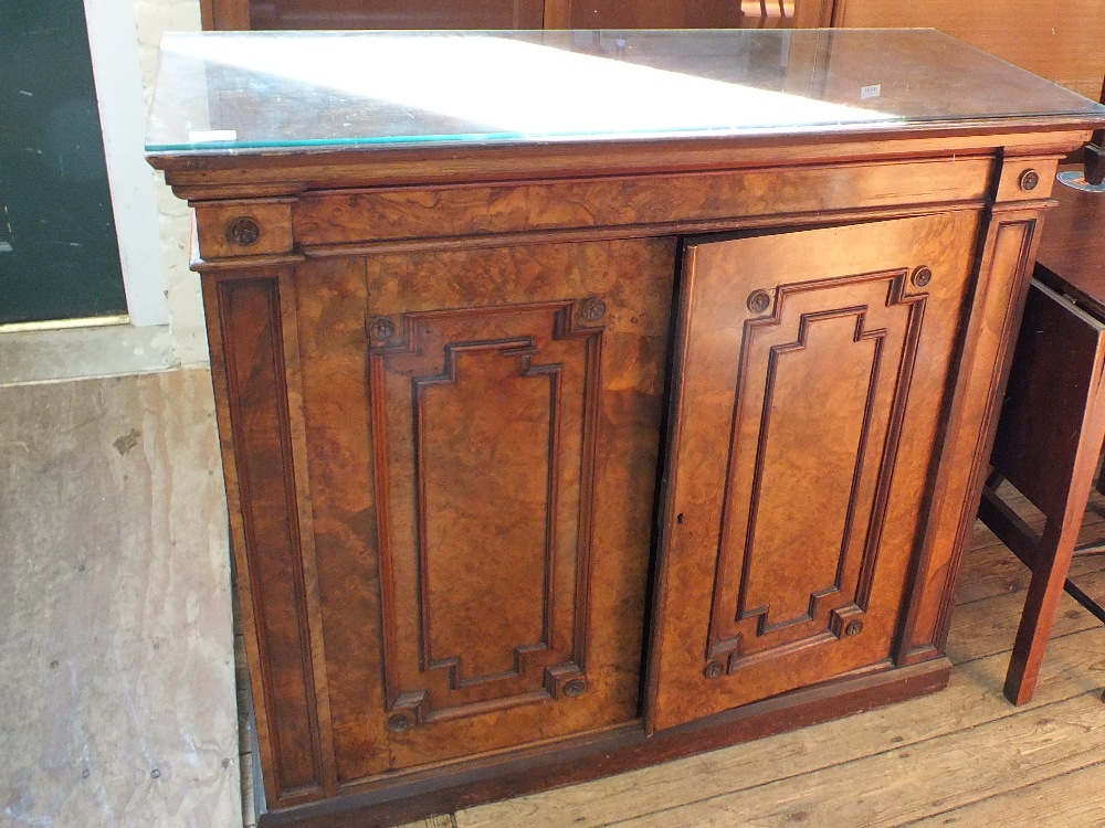 A 19th Century burr walnut two door cupboard with carved embelishment