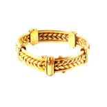 An unmarked gold panel bracelet with knot design