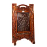 A mahogany fire screen with leaf and peacock carving