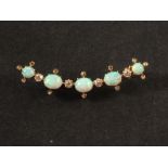 An unmarked gold crescent brooch set with five opals in between four diamonds and diamond chips