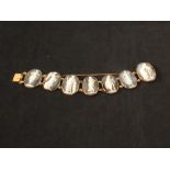 An 18ct gold bracelet set with seven cameos showing classical female figures (all panels are