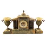 A green onyx striking mantel clock with its pair of matching garniture urns