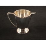 A silver cream jug with embossed top ring,
