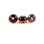 A pair of unmarked gold earrings with black enamel decoration set with single diamond centre plus a