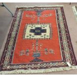 A good quality Persian red ground rug with vase designs and central blue cross,