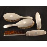 A five piece silver dressing table consisting of four brushes and one comb,