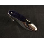 A large silver novelty pin cushion in the shape of a shoe,
