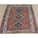 A Persian red ground rug with three medallions,