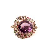 An unusual silver brooch set with a large amethyst to centre with diamond, emerald,