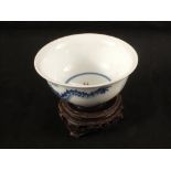A Chinese porcelain dragon and flaming pearl bowl on wooden stand