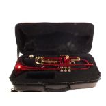 A cased Roy Benson brass and red finished trumpet