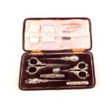 A silver and floral embossed sewing set,