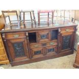 An Edwardian mahogany sideboard with carved panels and brass handles