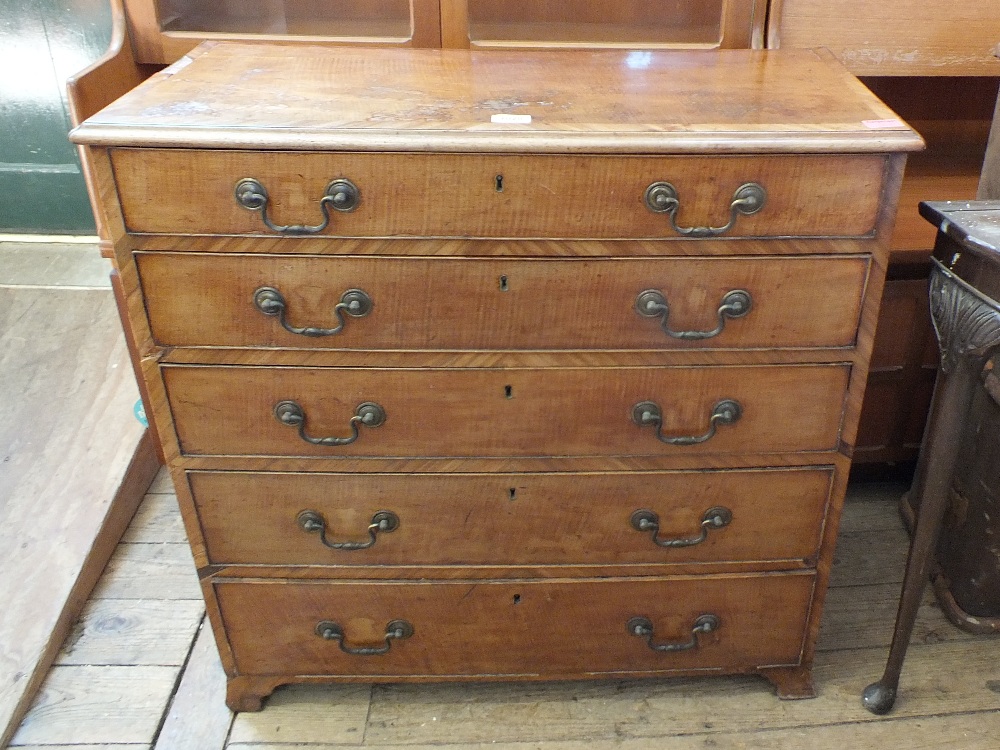 A Georgian style chest of five drawers with cross banded inlay on splayed feet