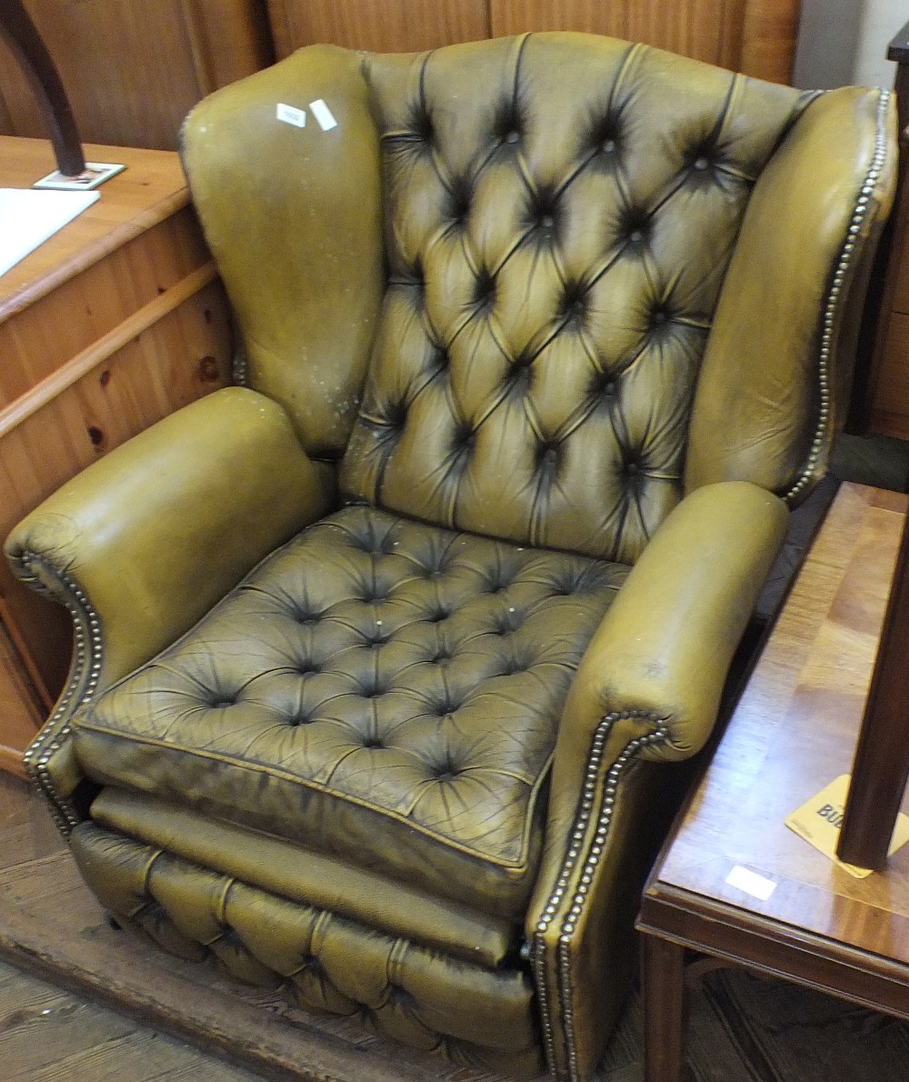 A large leather button back armchair