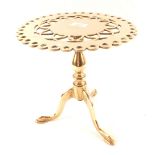 A heavy 19th Century brass trivet in the form of a tripod table with pierced circular top,