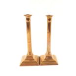 A pair of 18th Century seamed brass candlesticks with fluted cylindrical columns and engraved